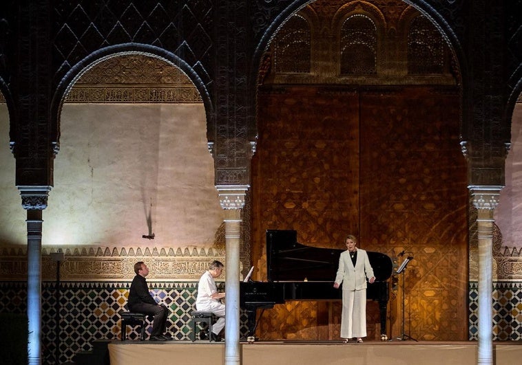 Una diva de blanco sobre fondo oscuro